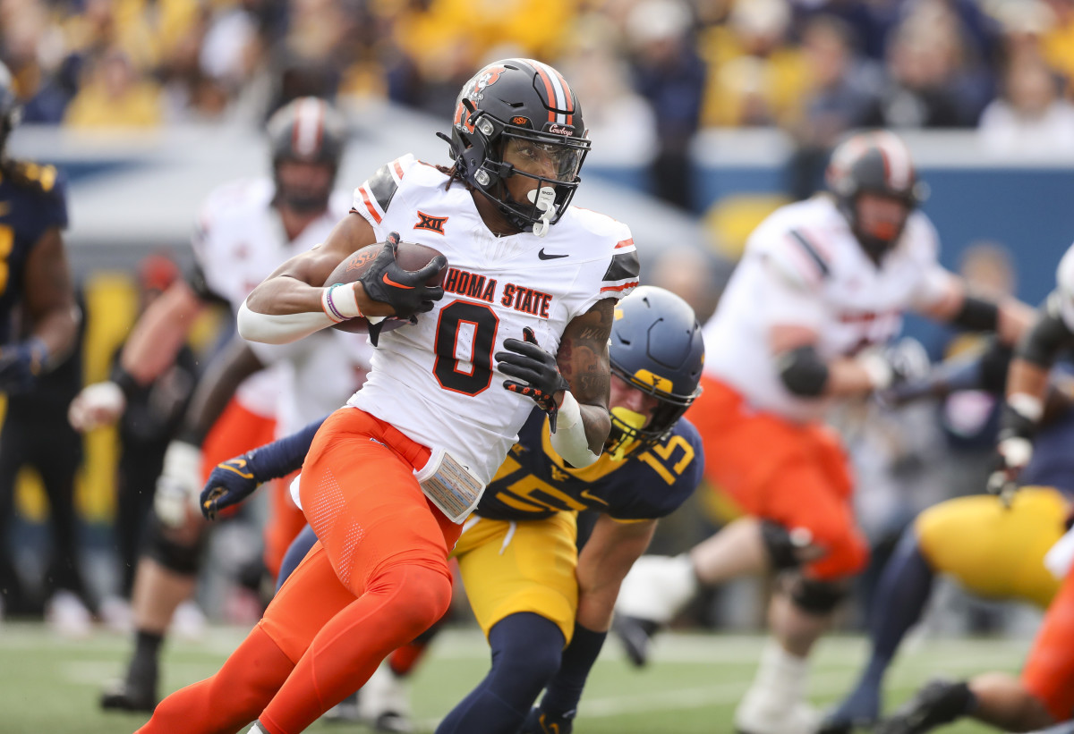 Oct 21, 2023; Morgantown, West Virginia, USA; Oklahoma State Cowboys running back Ollie Gordon II (0) runs for a touchdown during the first quarter against the West Virginia Mountaineers at Mountaineer Field at Milan Puskar Stadium. Mandatory Credit: Ben Queen-USA TODAY Sports